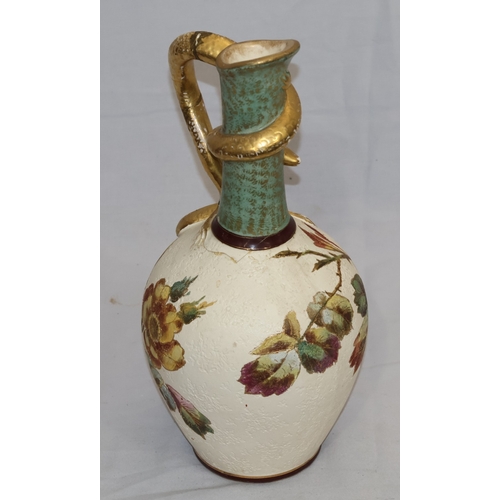 143 - A Bonn glazed china round bulbous thin necked jug with serpent handle, on white and green ground wit... 