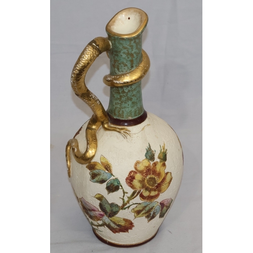 143 - A Bonn glazed china round bulbous thin necked jug with serpent handle, on white and green ground wit... 