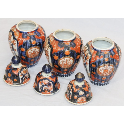 179 - A set of 3 Imari round bulbous melon shaped lidded pots with allover tree, floral, leaf and gilt dec... 
