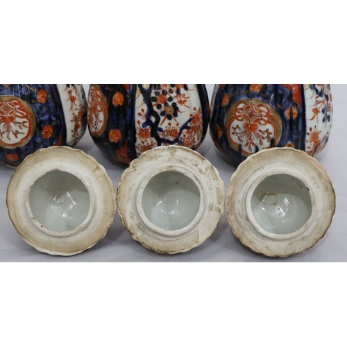 179 - A set of 3 Imari round bulbous melon shaped lidded pots with allover tree, floral, leaf and gilt dec... 