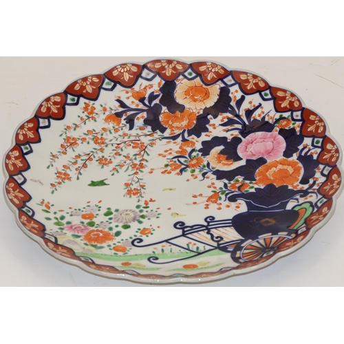 105 - An Imari round scallop shaped charger on white, red and blue ground with garden and bird decoration,... 