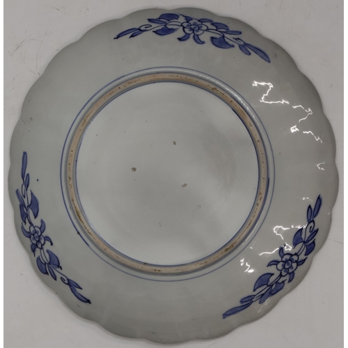 105 - An Imari round scallop shaped charger on white, red and blue ground with garden and bird decoration,... 