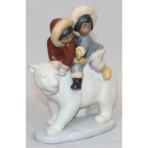 74 - A Lladro mat group of 2 Eskimo children on back of Polar Bear, 18cm high