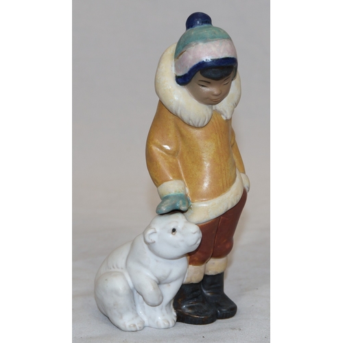 75 - A Lladro mat group of Eskimo standing next to baby Polar Bear, 15cm high