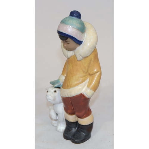 75 - A Lladro mat group of Eskimo standing next to baby Polar Bear, 15cm high