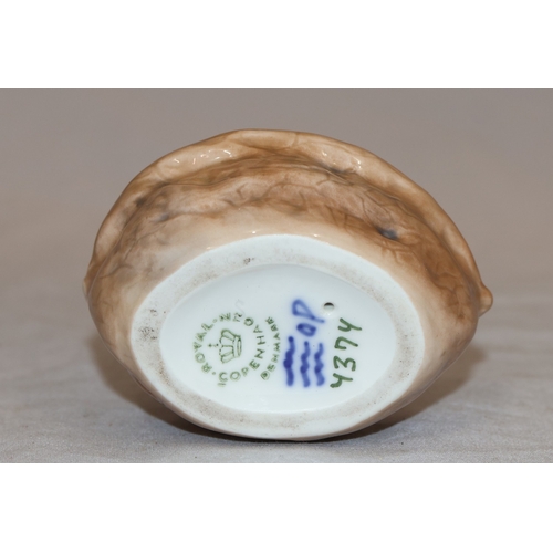 86 - A Royal Copenhagen small figure of a young girl seated in a basket holding a large leaf no. 4374, 9c... 