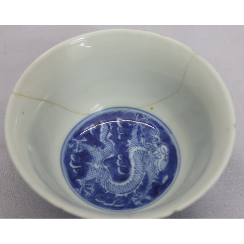 4297 - An Oriental blue and white round trumpet shaped tea bowl with dragon decoration (cracked and chipped... 