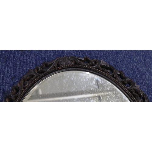 4004 - An oval carved wood mirror, 60cm x 50cm.