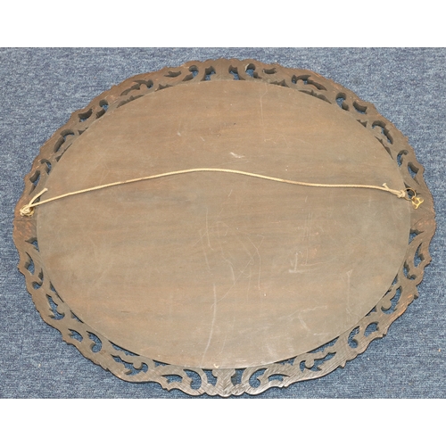 4004 - An oval carved wood mirror, 60cm x 50cm.
