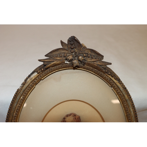 4061 - An oval miniature portrait of a young girl, 13.5cm x 12cm, in gilt frame (frame damaged, an inkwell ... 