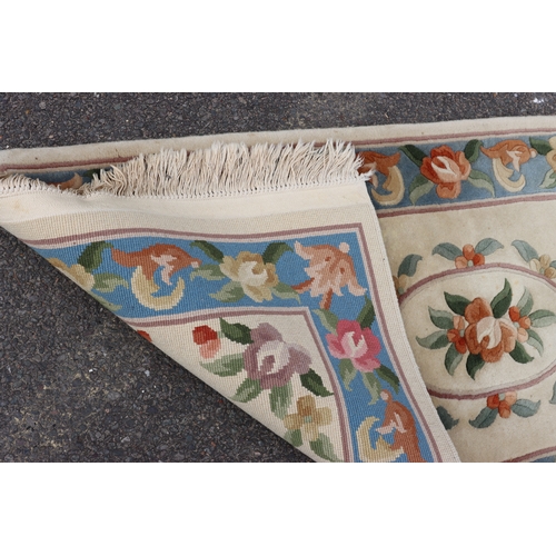 4075 - A small rug on cream ground with floral pattern, 176cm x 76cm (scattered spots and marks).