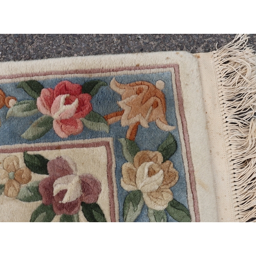 4075 - A small rug on cream ground with floral pattern, 176cm x 76cm (scattered spots and marks).