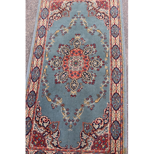 4076 - A small rug on blue ground, 138cm x 70cm (some spots and marks).