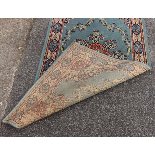 4076 - A small rug on blue ground, 138cm x 70cm (some spots and marks).