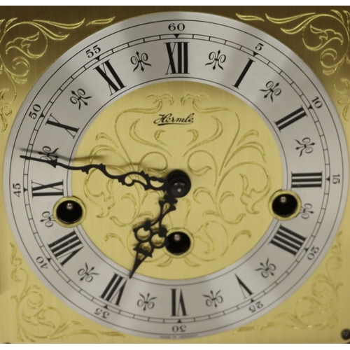4088 - A Hermle reproduction mahogany mantel clock, 25cm high.