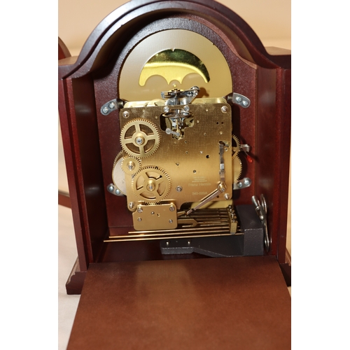 4088 - A Hermle reproduction mahogany mantel clock, 25cm high.