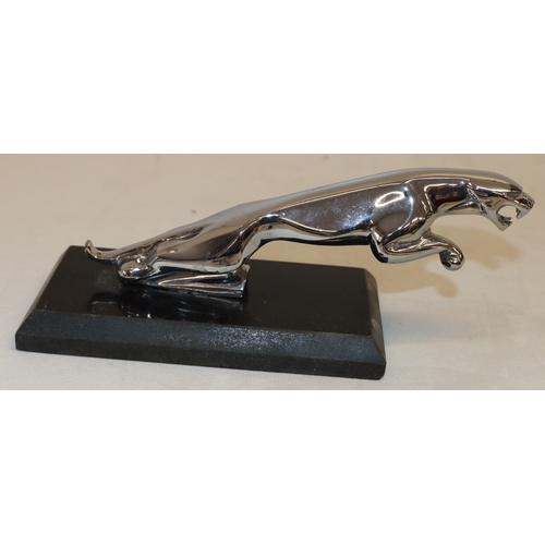 4107 - A modern car mascot style Jaguar on a marble plinth, 21cm long.