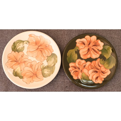 91 - 2 Moorcroft round plates on cream and green ground with coloured floral and leaf decoration, 26.5cm ... 