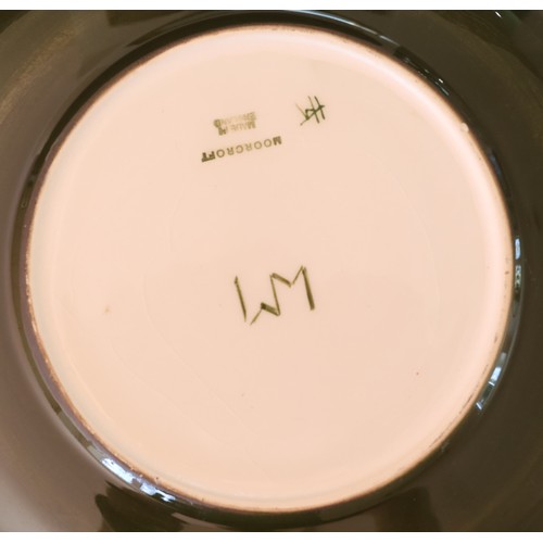 91 - 2 Moorcroft round plates on cream and green ground with coloured floral and leaf decoration, 26.5cm ... 