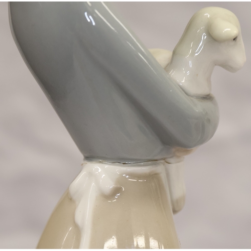 37 - 2 Lladro figurines; a Dutch boy carrying pails, 22cm high and a young girl holding a lamb, 27cm high... 