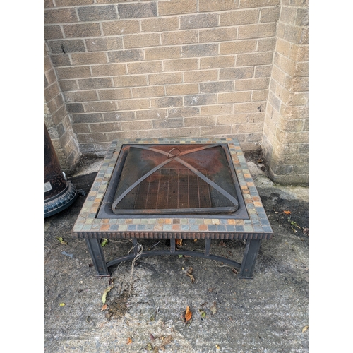 32 - A Metal Fire Pit With Tiled Surround