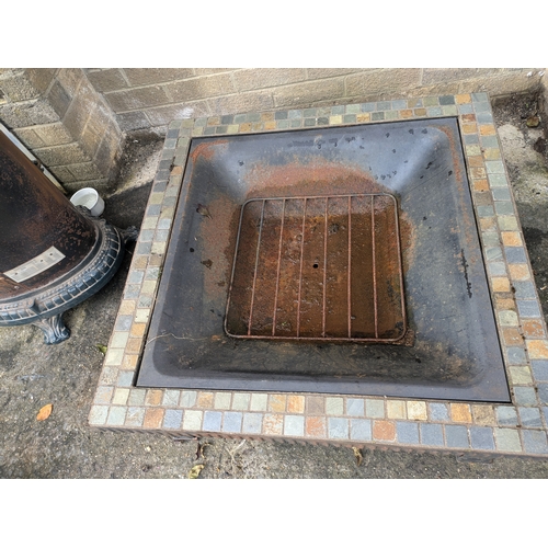 32 - A Metal Fire Pit With Tiled Surround