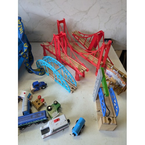 386 - a large selection of wooden train track with building, vehicles and characters