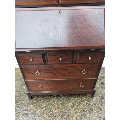 224 - A Stag Mahogany Varniered Pine Bureau with 5 Drawers and a top display cabinet section