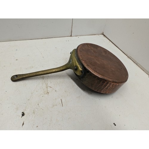 812 - An antique hand hammered copper and brass saucepan