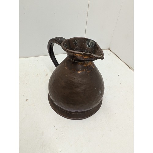 814 - A large antique copper jug with embossings in pewter on the lip