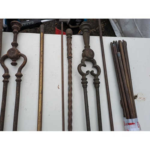 884 - A selection of brass and wrought iron fireside equipment and rods