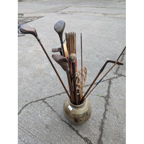 869 - A Large Aged Clay Pot With Walking Sticks, Golf Clubs, Etc