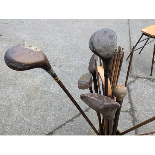 869 - A Large Aged Clay Pot With Walking Sticks, Golf Clubs, Etc