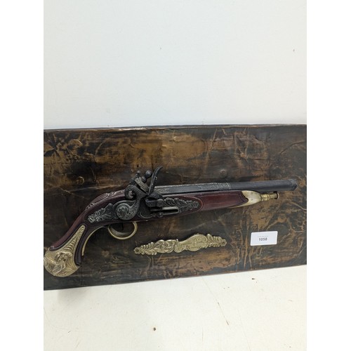 1058 - A Replica Flintlock Pistol mounted to a Copper wrapped backing