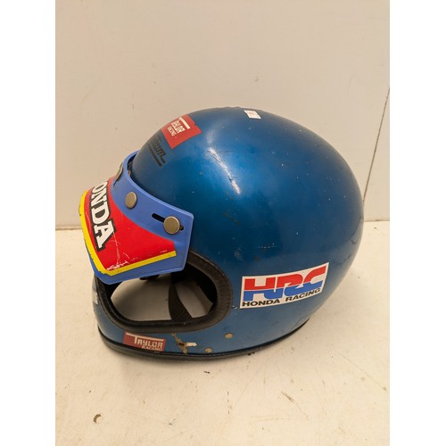 2057 - A Vintage Taylor & Sons Motorcycle helmet in a metallic blue colour, with various decals including H... 