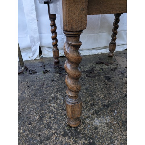 462 - An antique oak draw leaf extending dining table with crank extension handle and barley twist legs