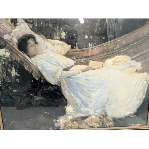 1897 - A framed print of a lady laying in a hammock reading a book - Munnings 1908