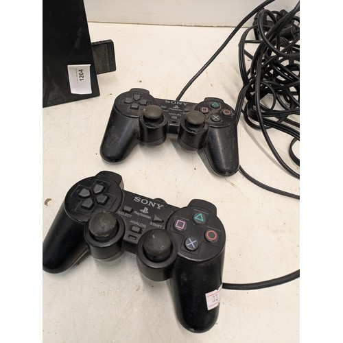 1204 - A Sony Playstation 2 console with cables and 2 controllers