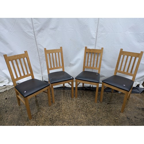 403 - A set of 4 oak dining chairs with black leather seat bases