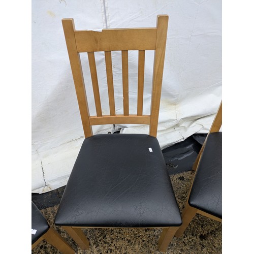 403 - A set of 4 oak dining chairs with black leather seat bases