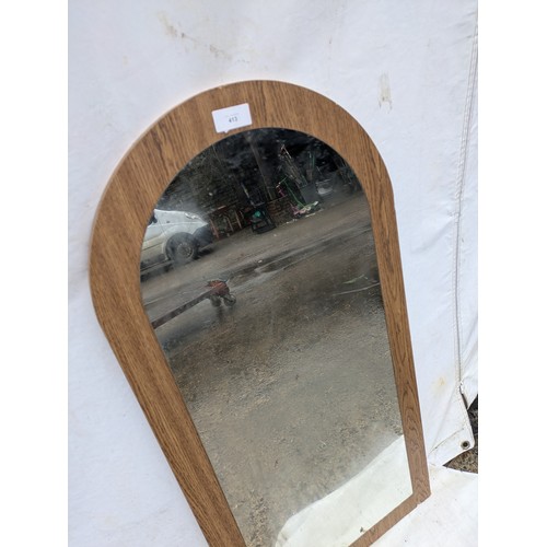 413 - A curved top mirror with an oak effect backing