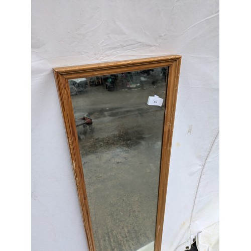 414 - A tall dressing mirror with a bevelled pine frame