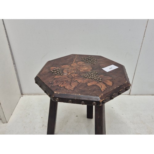 444 - A small octagonal topped pine stool - with engraved and patterned top