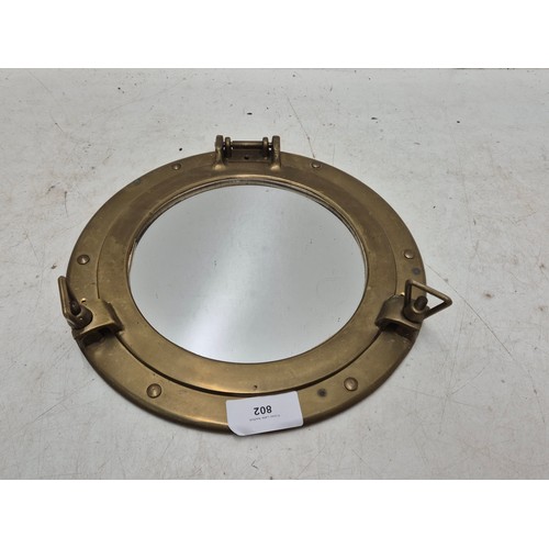 802 - A porthole style brass wall effect with an inlaid mirror