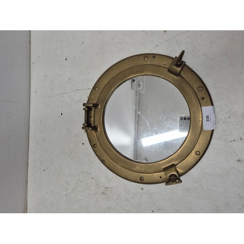 802 - A porthole style brass wall effect with an inlaid mirror