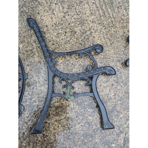 32 - A pair of cast iron bench ends with a cast iron back