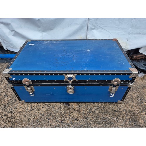 522 - A large blue canvas storage trunk with a large quantity of military clothing including trousers, jum... 