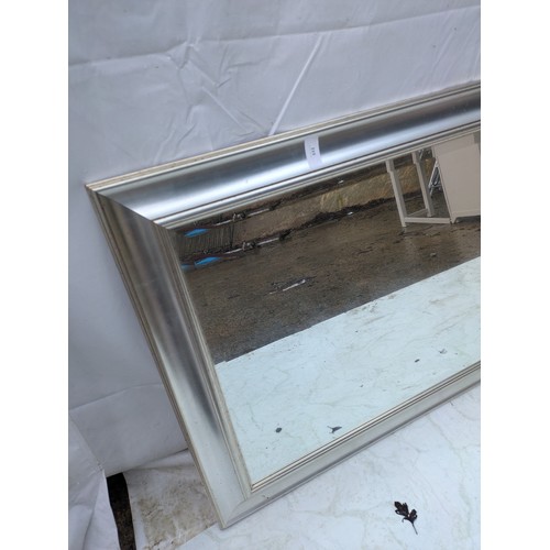 513 - A wall mounted mirror with a bevelled edge and silver frame