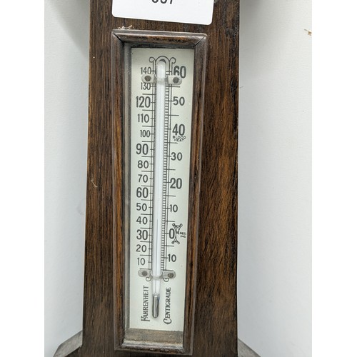 857 - An early 20th century thermometer and barometer on a carved oak base