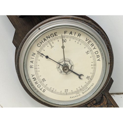 857 - An early 20th century thermometer and barometer on a carved oak base